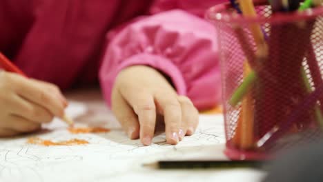 kids drawing with colored pencils. kids sitting at table and drawing with colored pencils