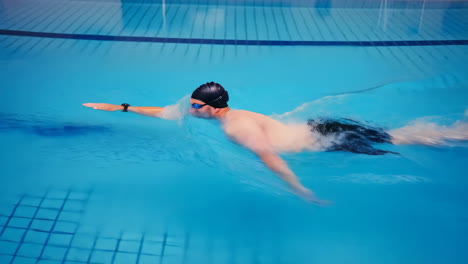 dynamic swimmer doing freestyle in a blue pool