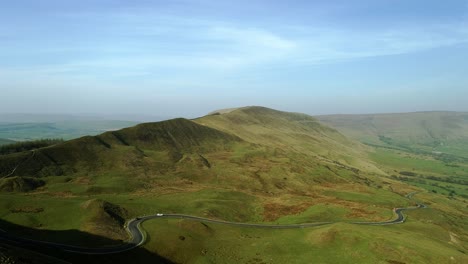 drone shot from the top of mam tor looking over winnats pass, peak district panning right and moving towards the road showing moving cars and mountains