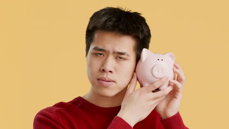 young man holding piggy bank