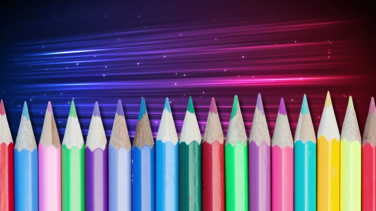 varios lápices de colores contra rastros de luz coloridos
