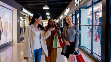 three happy women enjoying a shopping trip at a modern mall