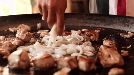 Fotograma-Cerrado-Sobre-Una-Cocina-Añadiendo-Calamares-A-La-Paella