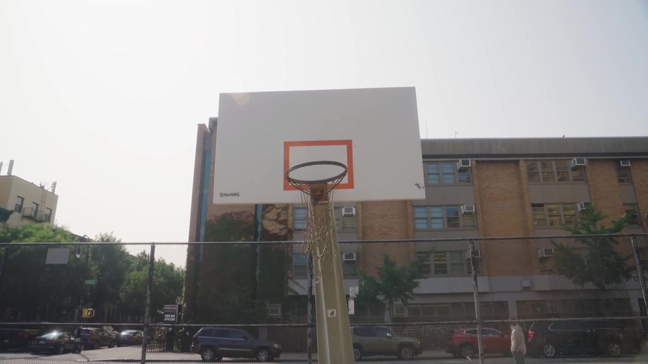 Campo da basket vuoto illuminato dal sole sul canestro, New York, USA