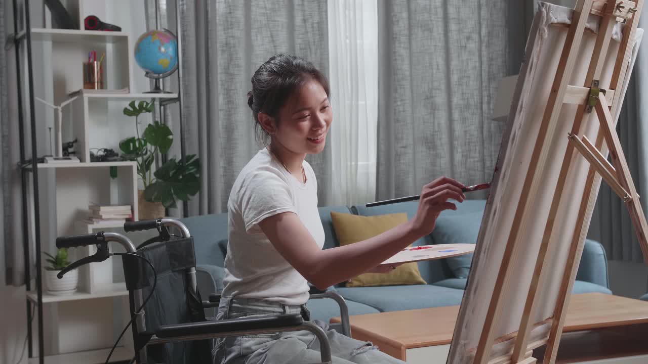 mujer en silla de ruedas pintando en casa