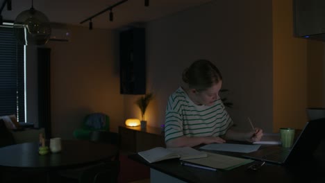 teenager studying at home at night