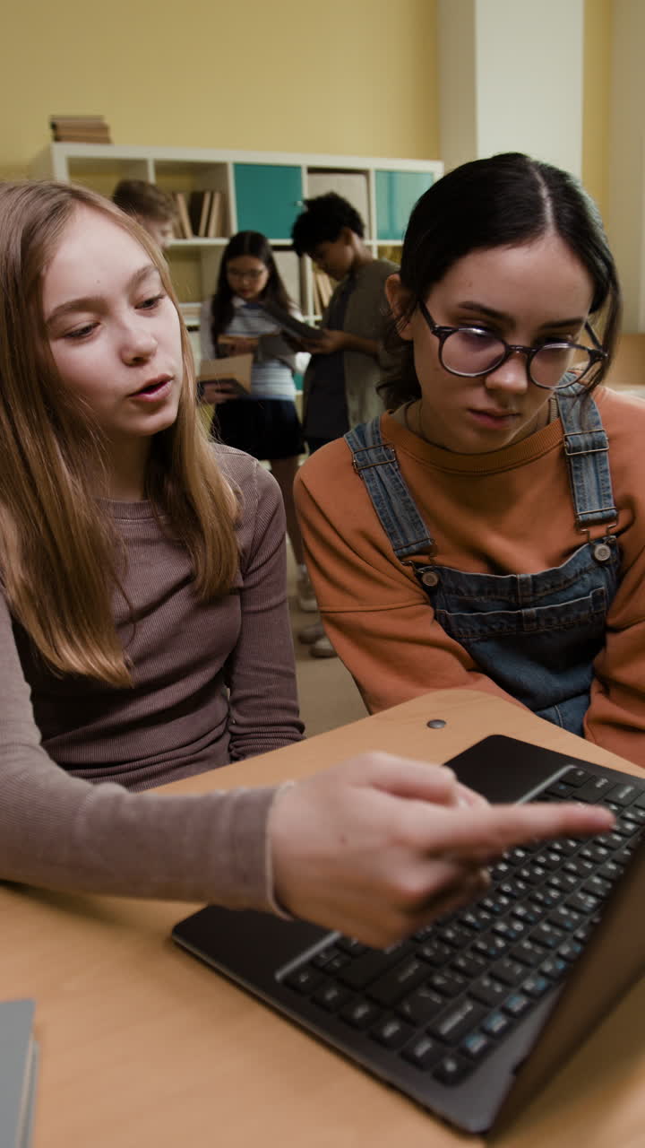 Students in a classroom using a laptop for learning