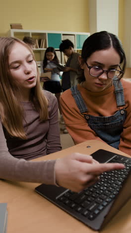 students in a classroom using a laptop for learning