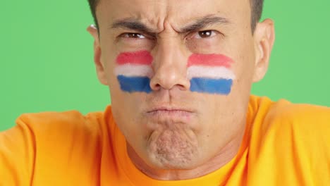 man with dutch national flag upset with a referee