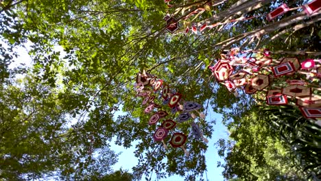 vibrant mobiles hanging among lush green trees