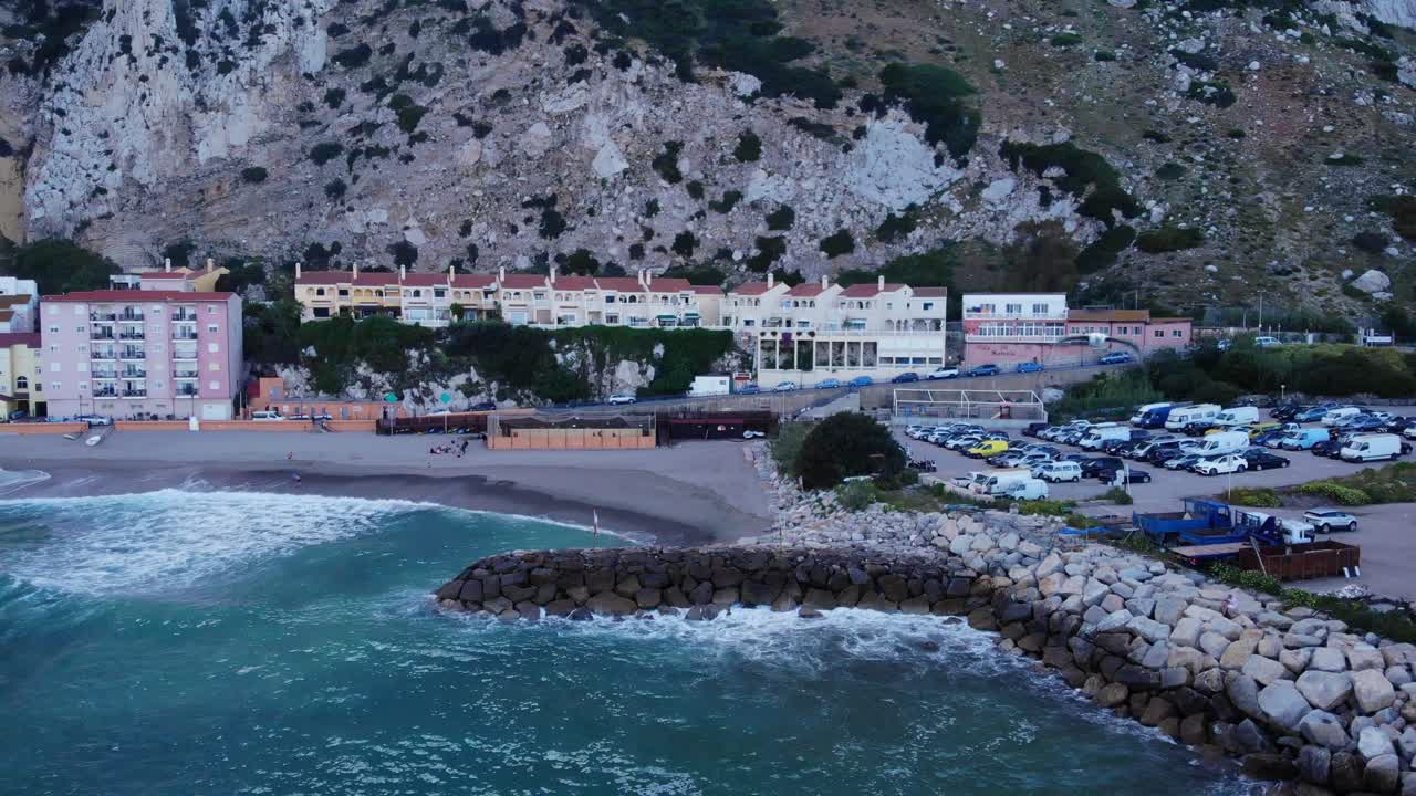 지브롤터의 카탈란 베이에 있는 바다 벽에 파도가 부서지는 청록색 해변