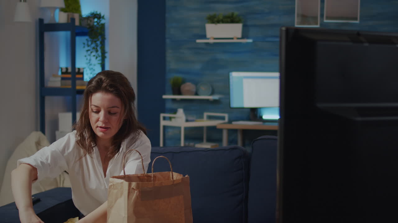 Young woman putting bag of takeaway food on table