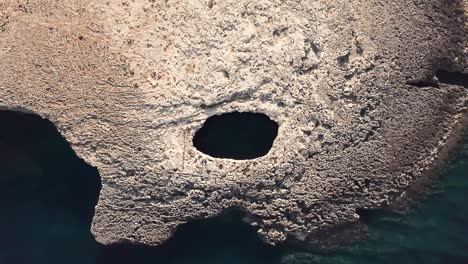 SWIMMING-HOLE-IN-MALTA-OCEAN-DRONE-PULL-UP-SHOT