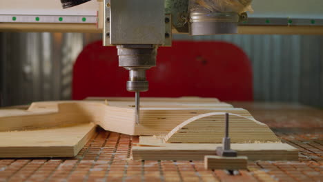 primer plano de la máquina de enrutador cnc en el trabajo en madera contrachapada creando un patrón geométrico complejo con precisión