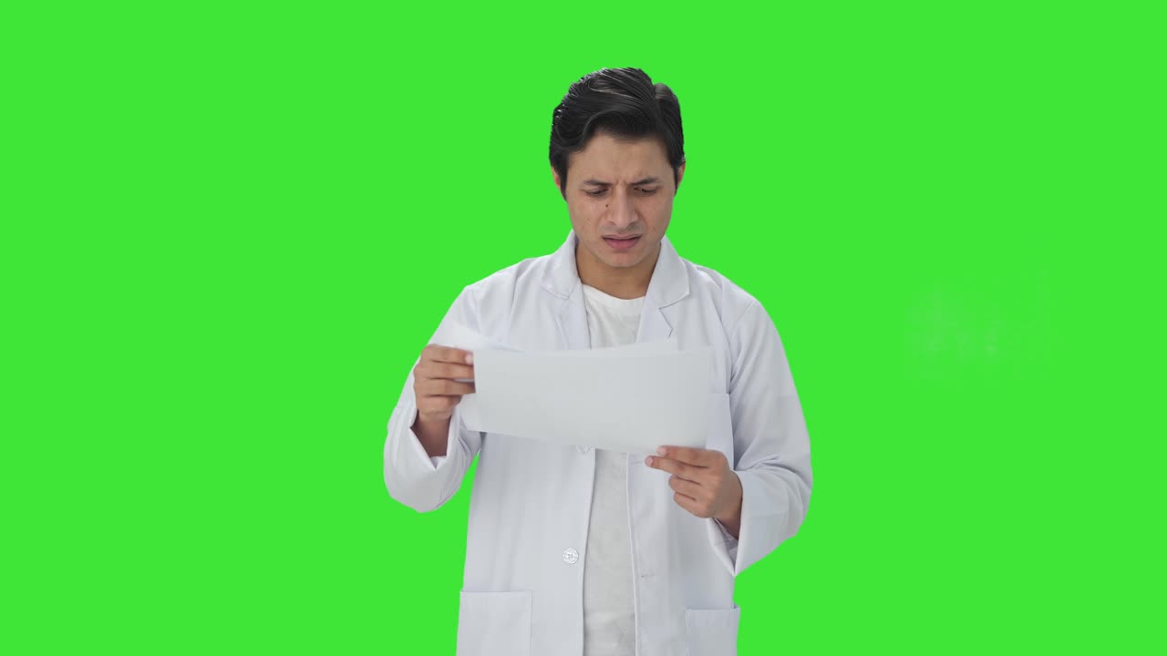 혼란스러운 인도 과학자가 연구 논문을 읽고 있는 그린 스크린