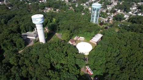 a top down drone view over a golf course, then tilt up to reveal water towers in a suburban neighborhood on long island, ny on a sunny day