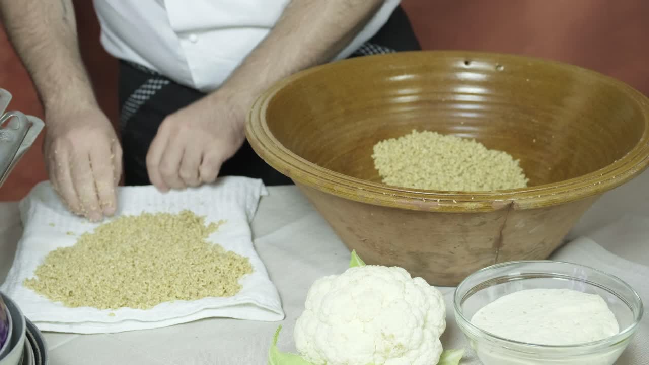 손으로 뜨거운 증기 쿠스쿠스를 천에 펴고 전통적인 아프리카 요리법, 세부 촬영