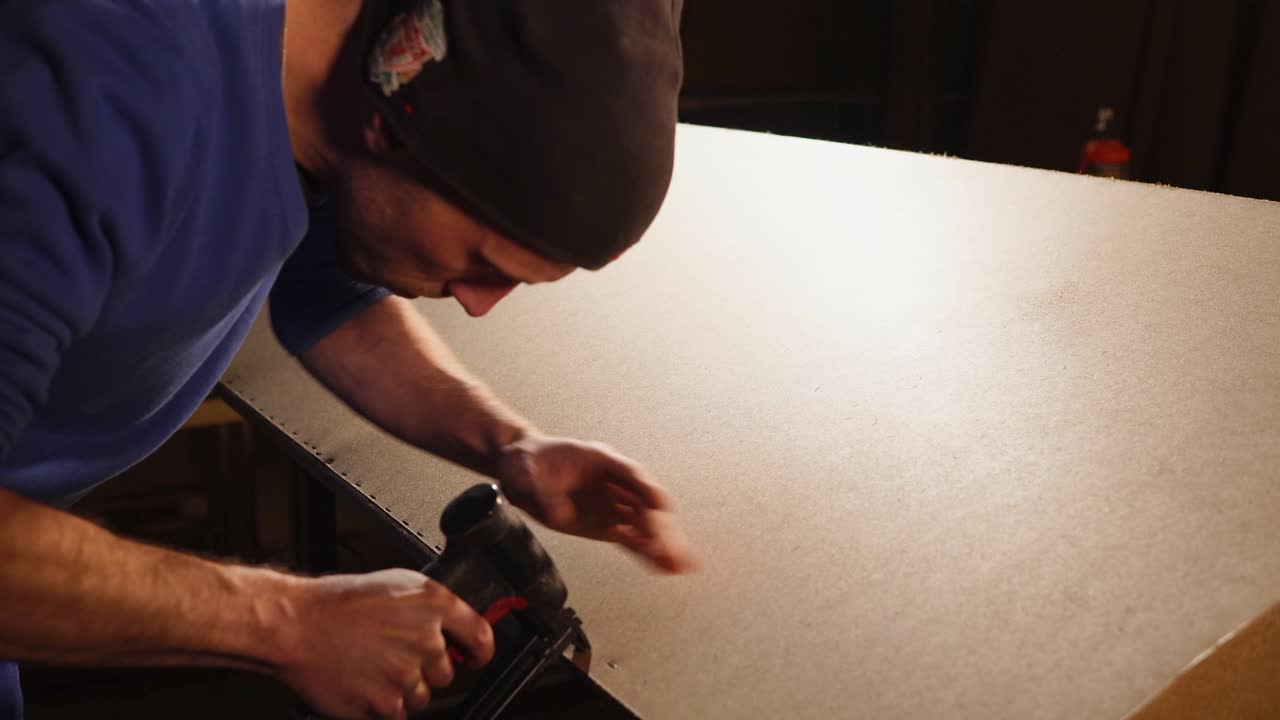 Carpenter Using Nail Gun to Assemble a Panel