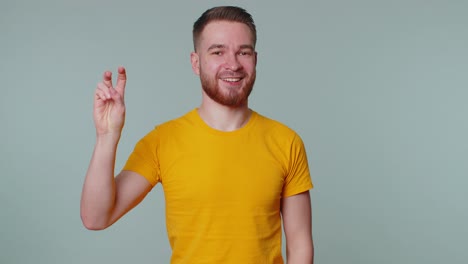 hombre sonriente y alegre mostrando el signo de la victoria, esperando el éxito y la victoria, haciendo un gesto de paz