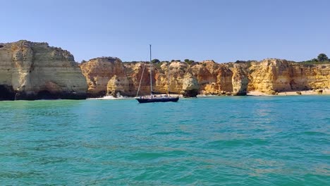 yate de 2 mástiles navegando a lo largo de la costa rocosa de la aguja de portugal