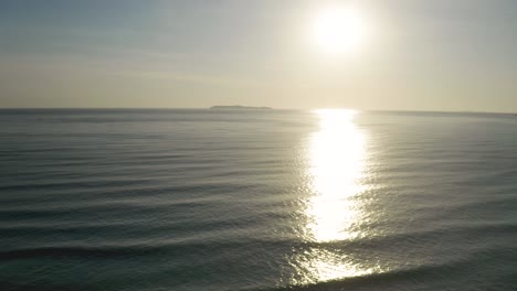 Beautiful-drone-going-up-revealing-the-ocean-of-a-brazilian-beach-at-sunrise