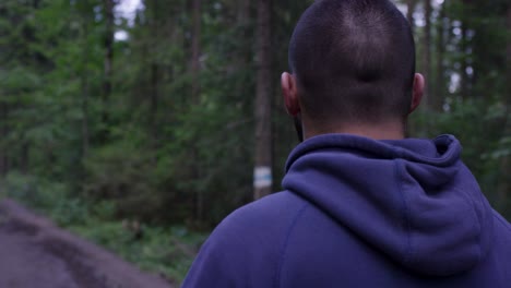 man listening to music while walking in a forest