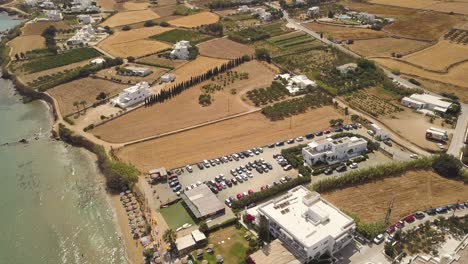 establishing shot of a parking lot near a public beach on the greek island of paros