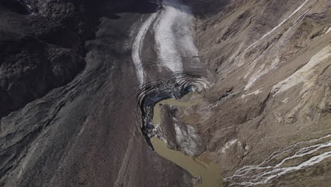 Aerial-view-of-Pasterze-glacier-mouth-melting-due-to-global-warming,-Glacier-covered-in-moraine,-Austria