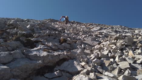 hiker ascending mountain behind rocks low angle circling kananaskis alberta canada