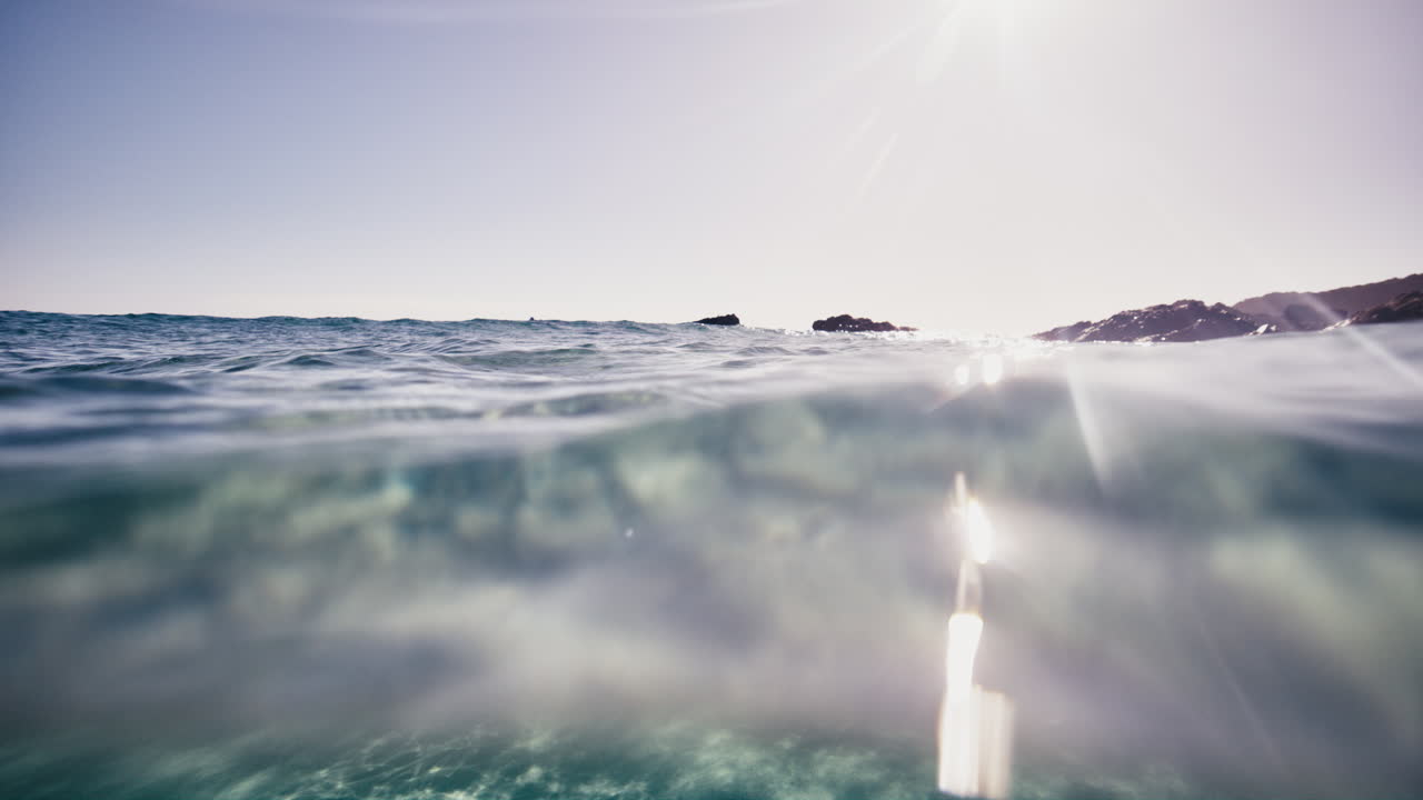 L'acqua blu e cristallina scintilla mentre delicati raggi di luce filtrano attraverso la superficie.