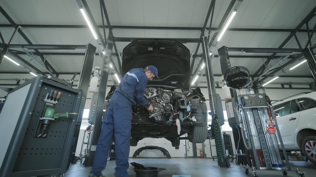 자동차 작업장에서 자동차 엔진을 수리하는 기계공