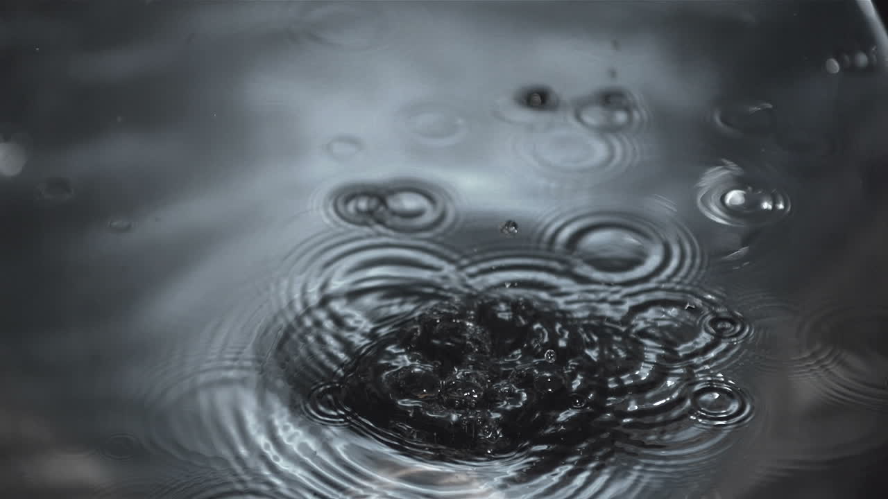 회색 물에 떨어지는 나무 반지