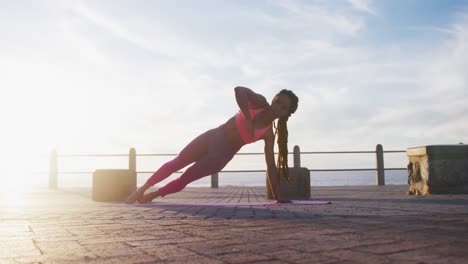 Mujer-Afroamericana-En-Ropa-Deportiva-Haciendo-Yoga-En-El-Paseo-Marítimo