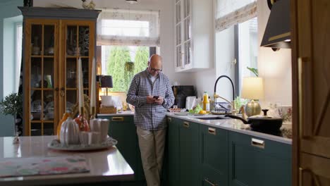 man using a smartphone in a modern kitchen