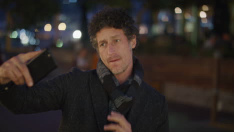 retrato atractivo hombre maduro turista usando un teléfono inteligente tomando una foto selfie en la cámara del teléfono móvil disfrutando de la vida nocturna urbana en la ciudad