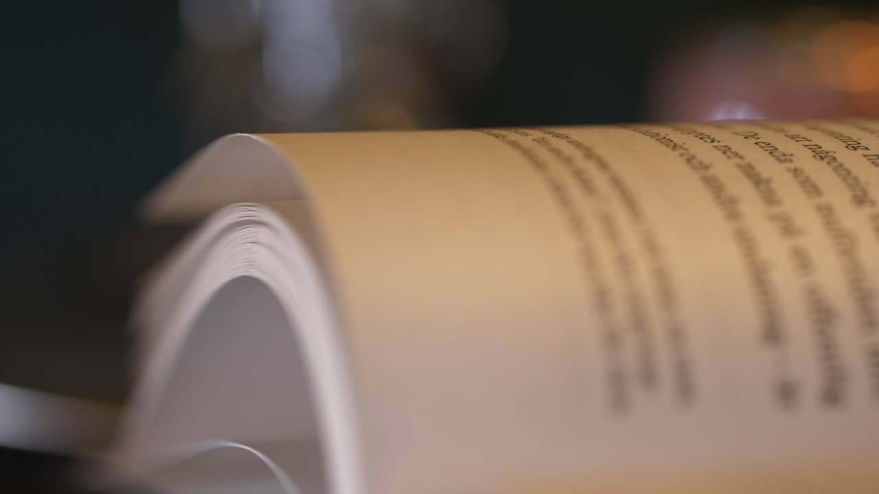 Dolly Sliding Shot of open book page, panning left to right, close up shallow depth of field