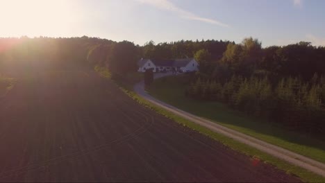 aerial video approaching a farm during sunset at low height