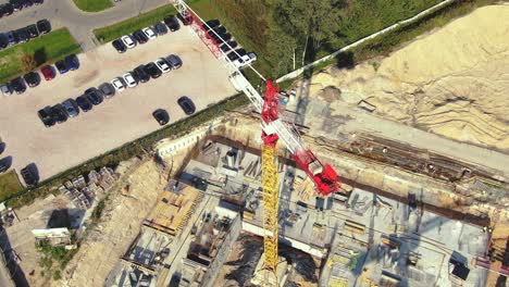 vuelo aéreo sobre un sitio de desarrollo de nuevas construcciones con grúas de torre alta que construyen bienes raíces