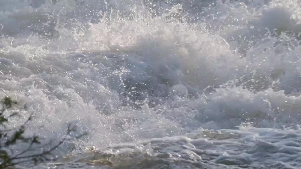 Intense white water rapids boil and churn violently in a display of natural hydraulic power. This detailed close up shows the frothy spray and rushing current of a spring river in Ontario.