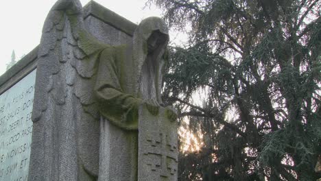 a ghostly angel looks down on a grave from above