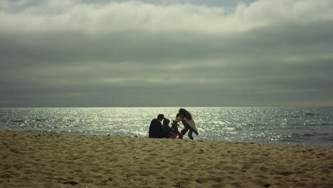 people taking photo beach by sea. young family enjoy make pictures on sunny day.