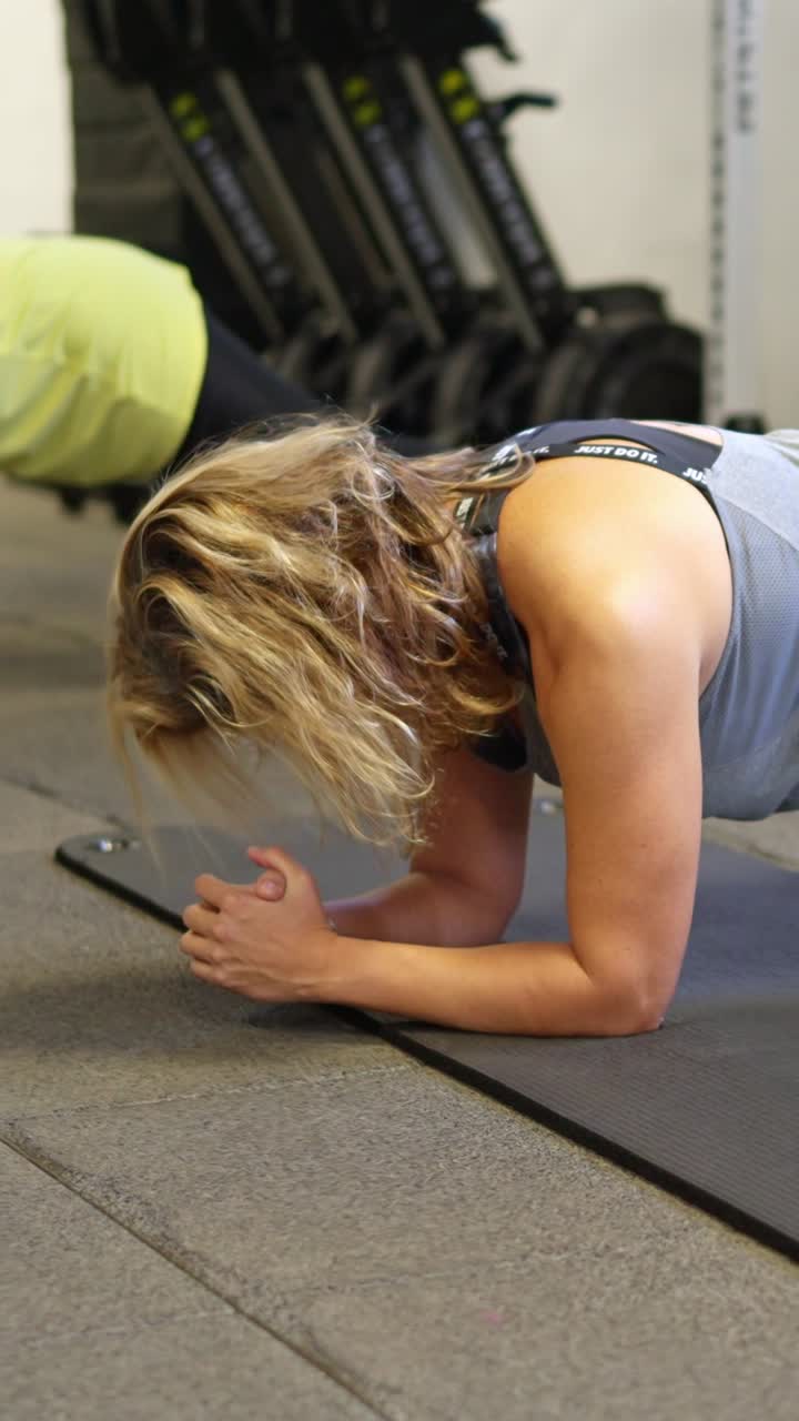 Woman Doing Plank Exercise on Mat in Gym