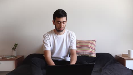 joven molesto y cansado trabajando desde casa sin entusiasmo