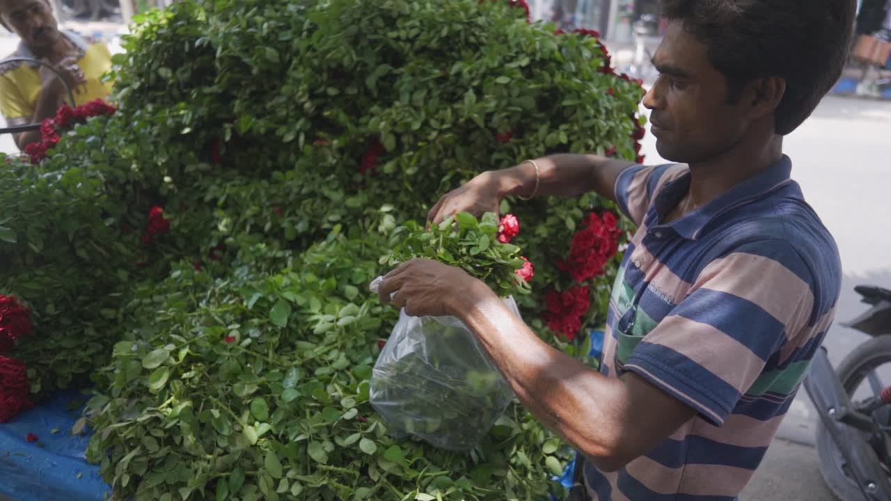 Flower seller street vendor packing flowers to customer at road side on street, slow motion