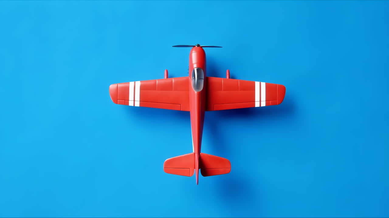 Rött leksaksflygplan med snurrande propeller på blå bakgrund