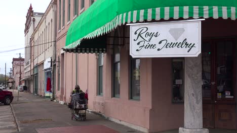 un anciano negro sin hogar empuja sus pertenencias por las calles de selma alabama