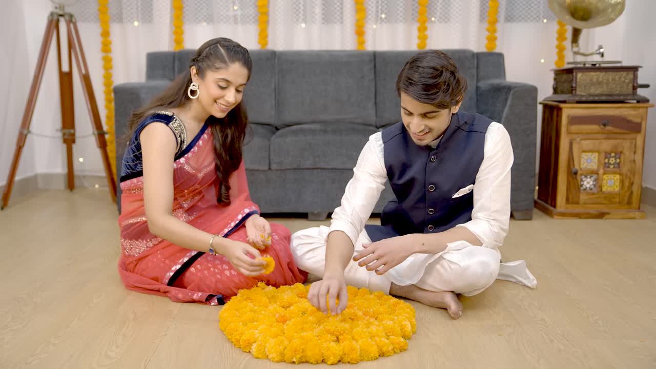 pareja india haciendo rangoli de flores