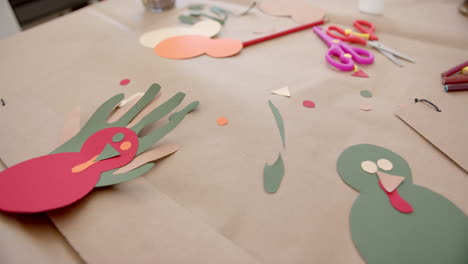 coloured paper, crayons, scissors and cutouts lying on table