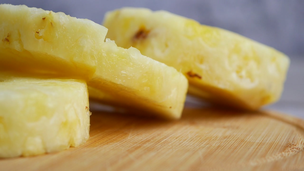 Fette fresche di ananas su un tagliere di legno