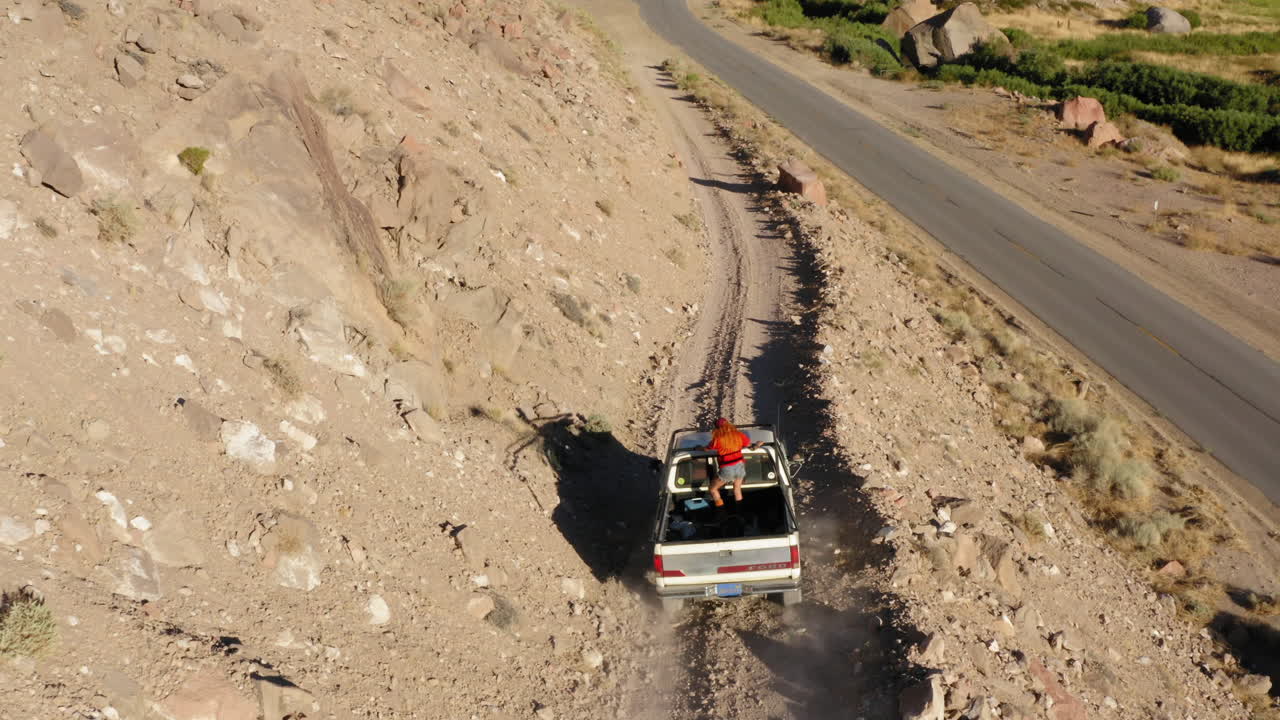 imágenes aéreas de un coche conduciendo por una carretera de montaña y bajando a una carretera en bishop, ca.